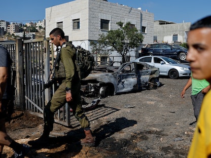 جندي إسرائيلي يقف أمام منزل فلسطيني تعرض لهجوم مستوطنين بالقرب من رام الله في الضفة الغربية المحتلة. 21 يونيو 2023 - REUTERS