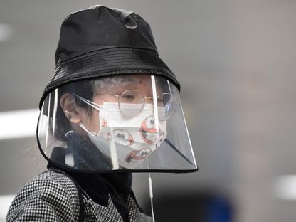 سيدة ترتدي قناع وجه بلاستيكي وسط انتشار فيروس "كورونا" في إيطاليا - AFP