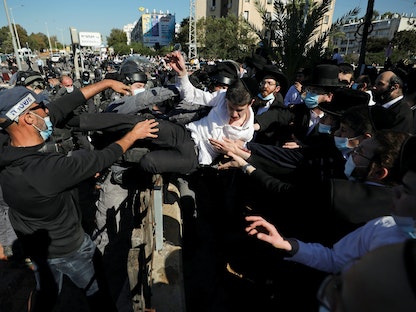 رجال شرطة يشتبكون مع محتجين على قيود فيروس كورونا في إسرائيل ، 24 يناير - REUTERS