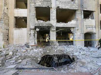 قوات الأمن السورية تفحص مبنى دمرته ضربة جوية إسرائيلية على دمشق- 19 فبراير 2023 - AFP
