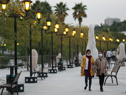 فتيات إيرانيات يرتدين أقنعة يمشين في متنزه بالعاصمة طهران، 14 أغسطس 2021 - VIA REUTERS