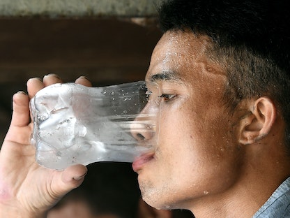 عامل فيتنامي يشرب الماء أثناء استراحته، 21 مايو 2020 - AFP