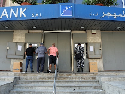 أشخاص يستخدمون أجهزة الصراف الآلي في فرع مغلق لبنك لبنان والمهجر في بيروت. 21 سبتمبر 2022 - REUTERS