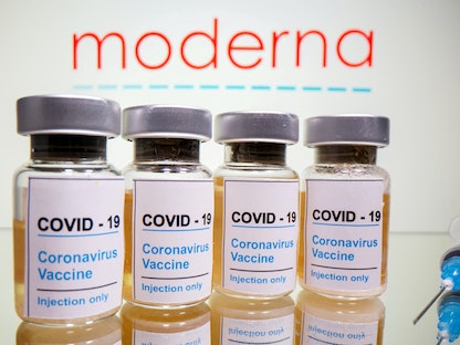 قوارير للقاح موديرنا المضاد لكوفيد-19 أمام شعار شركة موديرنا، 31 أكتوبر 2020  - REUTERS