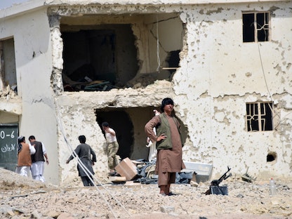 أفغان يتفقدون الدمار الذي لحق بالمباني بعد انفجار قنبلة في محافظة قندهار - REUTERS