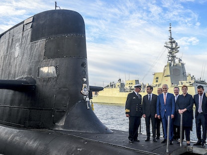الرئيس الفرنسي إيمانويل ماكرون (الثاني يسار) ورئيس الوزراء الأسترالي السابق مالكولم تورنبول (وسط) يقفان على ظهر غواصة "HMAS Waller" تديرها البحرية الملكية الأسترالية، في جاردن آيلاند، سيدني - 2 مايو 2018. - AFP