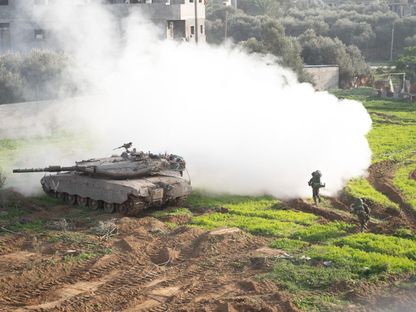 دبابة إسرائيلية وجنود خلال مواجهات شرقي خان يونس في جنوب قطاع غزة. 18 يناير 2024 - AFP