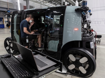 موظفون يعملون على خط تجميع مركبة Zoox ذاتية القيادة تملكها أمازون في مصنع الشركة في فريمونت، ولاية كاليفورنيا، الولايات المتحدة الأميركية - 19 يوليو 2022 - REUTERS