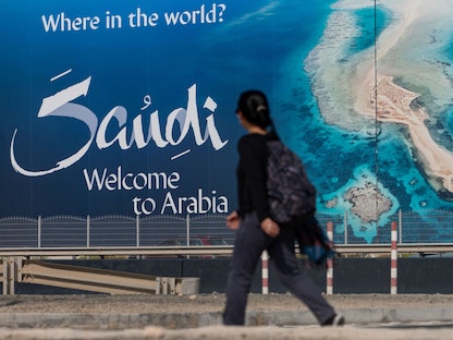 طفلة تمر بالقرب من لوحة إعلانات عن السياحة في السعودية - Photographer: Bloomberg/Bloomber