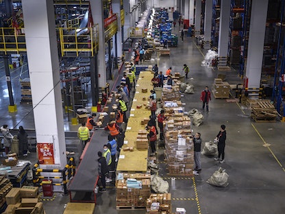 عمال من شركة التجارة الإلكترونية الصينية JD.com في مستودع بالمركز اللوجستي الرئيسي للشركة خلال يوم العزاب، 11 نوفمبر 2020 - Getty Images