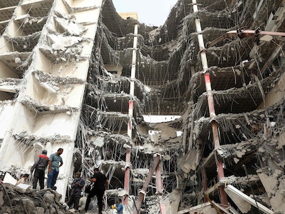 إيرانيون في موقع انهيار المبنى بمدينة عبادان - 24 مايو 2022 - AFP