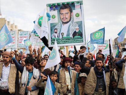 أنصار الحوثيين يحملون أسلحة وصورة زعيم الجماعة عبد الملك الحوثي خلال تجمع للاحتفال بالذكرى السابعة لسيطرتهم على صنعاء. 21 سبتمبر 2021.  - REUTERS