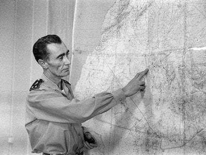 الجنرال الفرنسي جان تيري يضع يده على خارطة للجزائر، وهو يتحدث للصحافيين عن انفجار القنبلة النووية الفرنسية الثالثة في 27 ديسمبر 1960 بمنطقة رقان جنوبي الجزائر، خلال عملية "الجربوع الأحمر" - AFP