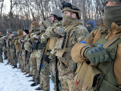 جنود من كتيبة آزوف الأوكرانية يصلّون في خاركوف، أوكرانيا- 11 مارس 2022. - AFP