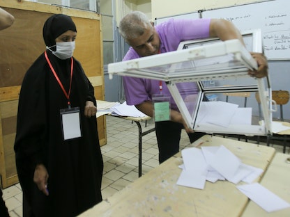 موظفو الانتخابات يفرغون صندوق اقتراع في نهاية التصويت في الانتخابات البرلمانية في الجزائر العاصمة - 12 يونيو 2021 - REUTERS