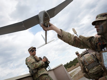 عناصر من الجيش الأميركي يفحصون طائرة تجسس مسيّرة  - REUTERS
