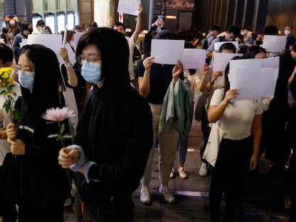 صينيون يحملون أوراقاً بيضاء أثناء احتجاج على قيود كورونا، في هونج كونج 28 نوفمبر 2022 - REUTERS