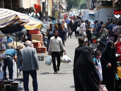إيرانيون يسيرون في أحد أسواق العاصمة طهران- 1 مايو 2022 - REUTERS