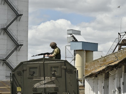 جندي روسي يحرس رافعة حبوب في مدينة ميليتوبول بمنطقة زاباروجيا الأوكرانية - 14 يوليو 2022 - AFP