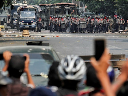 شرطيون في مواجهة متظاهرين مناهضين للانقلاب في ماندالاي بميانمار - 3 مارس 2021 - REUTERS