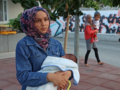 كوثر رسلان تحمل مولودها الحديث "يزن" في مخيم كوفينو قرب مدينة لارنكا الساحلية القبرصية - 22 سبتمبر 2021  - AFP