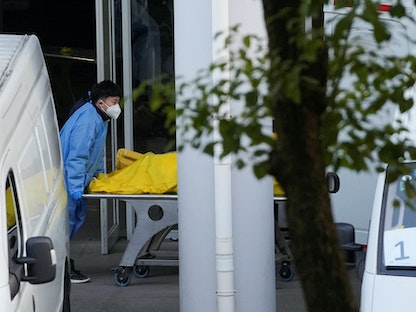 عامل يدفع عربة تحمل حقيبة جثث في أحد المدافن مع استمرار تفشي فيروس كورونا في شنغهاي الصين.  4 يناير 2023 - REUTERS