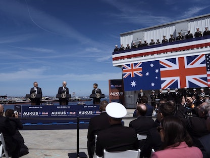 الرئيس الأميركي جو بايدن بين رئيسي وزراء بريطانيا ريشي سوناك وأستراليا أنتوني ألبانيز في قاعدة عسكرية بولاية كاليفورنيا لإعلان تفاصيل اتفاق "أوكوس". 13 مارس 2023 - Bloomberg