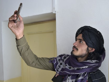 أحد مقاتلي طالبان يبحث عن إشارة لشبكة الهاتف المحمولفي منطقة أندار بإقليم غزنة - أفغانستان - 3 يونيو 2021 - AFP
