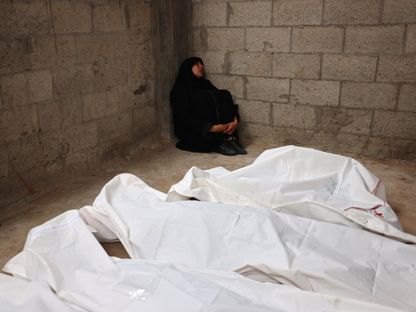 امرأة فلسطينية تجلس أمام جثامين أفراد أسرتها الذين قتلتهم إسرائيل في قصف على مدينة رفح جنوب قطاع غزة. 29 أبريل 2024 - AFP