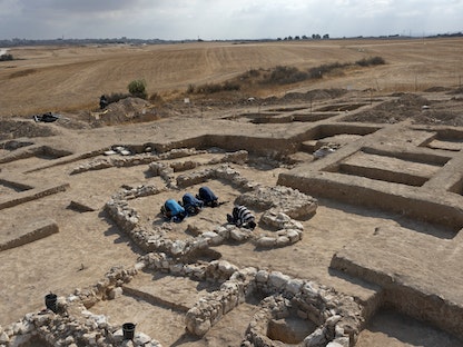 عمال فلسطينيون يعملون في سلطة الآثار الإسرائيلية يؤدون الصلاة وسط بقايا مسجد قديم تم اكتشافه أخيراً في بلدة راهط البدوية في صحراء النقب جنوب إسرائيل - 22 يونيو 2022 - AFP
