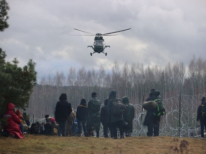 مهاجرون يتجمعون بالقرب من سياج الأسلاك الشائكة في محاولة لعبور الحدود إلى بولندا من منطقة جرودنو في بيلاروسيا - 8 نوفمبر 2021 - REUTERS