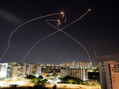 تشير خيوط الضوء إلى اعتراض نظام القبة الحديدية صواريخ تطلق من قطاع غزة باتجاه إسرائيل، عسقلان، 13 مايو 2021 - REUTERS