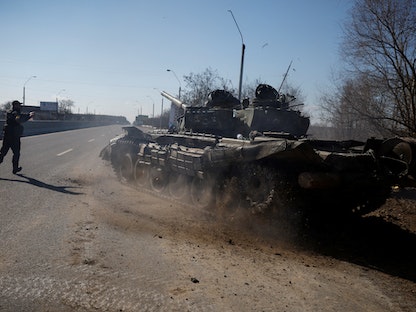 جندي أوكراني يوجه دبابة روسية أسرها أوكرانيون بعد قتال مع القوات الروسية خارج بروفاري، أوكرانيا - REUTERS