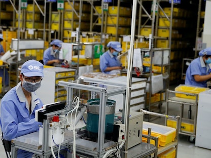 موظفون في مصنع تابع لشركة SMC خلال جولة منظمة حكومية لمنشآتها في أعقاب تفشي  جائحة كورونا  - REUTERS