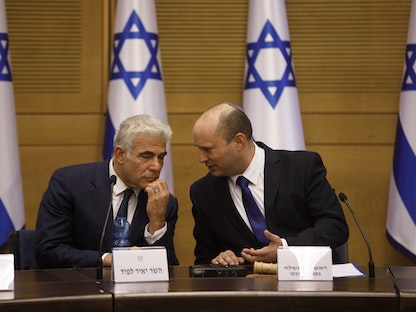رئيس الوزراء الإسرائيلي نفتالي بينيت (يمين) ووزير الخارجية يائير لَبيد خلال جلسة للحكومة في القدس - 13 يونيو 2021 - Bloomberg