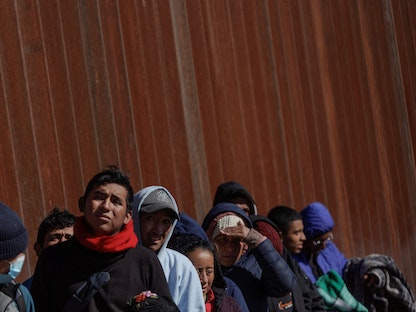 مهاجرون ينتظرون على طول السياج الحدودي بين المكسيك والولايات المتحدة. 22 ديسمبر 2022 - REUTERS