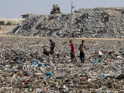 أطفال فلسطينيون يقفون وسط مكب النفايات في خان يونس يجنوب قطاع غزة. 30 أكتوبر 2025 - Reuters