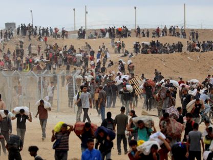 فلسطينيون يحملون مساعدات تلقوها من مؤسسة غزة الإنسانية (GHF) وسط قطاع غزة. 1 أغسطس 2025 - REUTERS