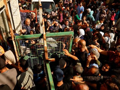 فلسطينيون يصطفون في طابور أثناء انتظارهم لشراء الخبز من مخبز في خان يونس جنوب قطاع غزة. 17 نوفمبر 2023 - رويترز
