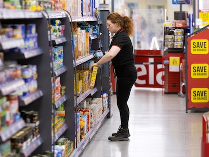 موظفة تملأ أرفف أحد المتاجر في كرايستشيرش بالمملكة المتحدة. 15 يونيو 2022 - Bloomberg