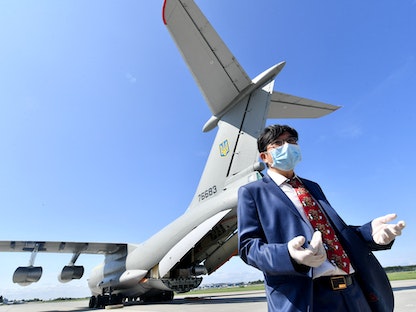 السفير الصيني لدى أوكرانيا فان شينرونج في مطار كييف، أثناء تسليم مساعدات إنسانية لمواجهة جائحة كورونا. يونيو 2020. - AFP