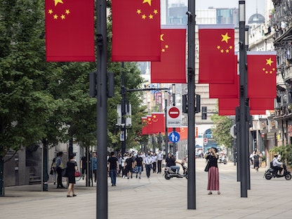 أعلام صينية في أحد شوارع مدينة شنغهاي - 1 يوليو 2021 - Bloomberg