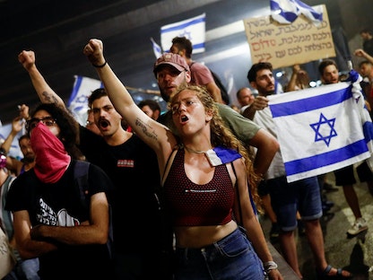 متظاهرون إسرائيليون يغلقون طريق أيالون السريع خلال مظاهرة في تل أبيب بعد تصويت الكنيست على مشروع قانون يحد من صلاحيات المحكمة العليا في إسرائيل. 25 يوليو 2023 - REUTERS