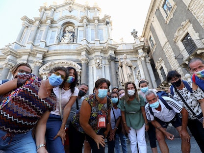 أشخاص يرتدون الكمامات يقفون لالتقاط صورة مع عودة صقلية إلى لقيود أكثر صرامة لمواجهة فيروس كورونا، إيطاليا، 30 أغسطس 2021 - REUTERS