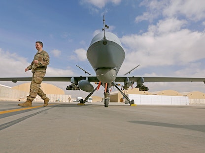 جندي أميركي أمام مسيّرة من طراز "MQ-9 Reaper" في قاعدة "قندهار" الجوية بأفغانستان. 23 يناير 2018 - REUTERS