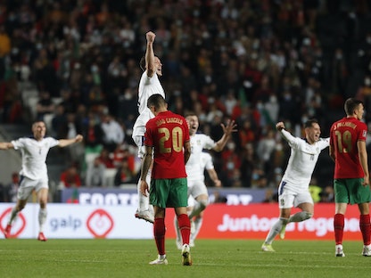 احتفالات لاعبي منتخب صربيا بالتأهل إلى المونديال وسط خيبة لاعبي البرتغال، 14 نوفمبر 2021 - REUTERS