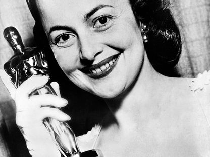 الممثلة الأميركية أوليفيا دي هافيلاند تحمل جائزة "أوسكار" لأفضل ممثلة عام 1950 - AFP