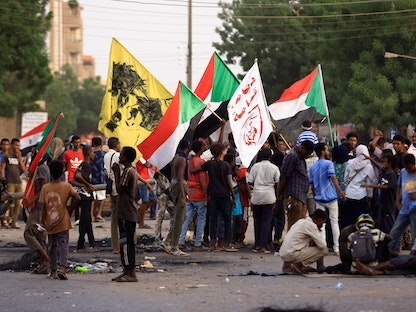 متظاهرون يرفعون أعلام السودان خلال اعتصام للمطالبة بحكم مدني. 3 يوليو 2022 - REUTERS