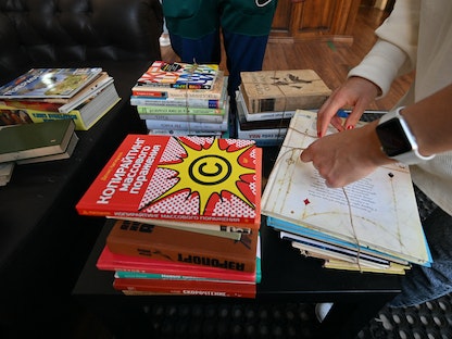 صورة تُظهر أشخاصاً يفرزون كتباً باللغة الروسية لإرسالها لمكتبة Siayvo لإعادة تدويرها، كييف -18 سبتمبر 2022  - AFP
