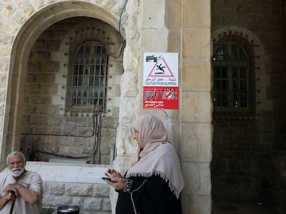 فلسطينيان خارج مستشفى "أوجستا فيكتوريا" في القدس الشرقية - 10 سبتمبر 2018. - REUTERS